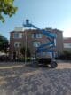 Kniktelescoophoogwerker in straat voor huis hoogwerker huren bij Gromax